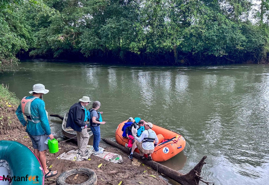 Getting on a raft - a group of elderly tourists are waiting at a river bank, to get onto an inflatable raft with two tour guides helping them onto the raft in Costa Rica 