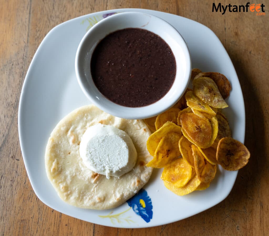 A photo of plantain chips, slow cooked mashed beans, corn tortilla and cheese in Costa Rica 