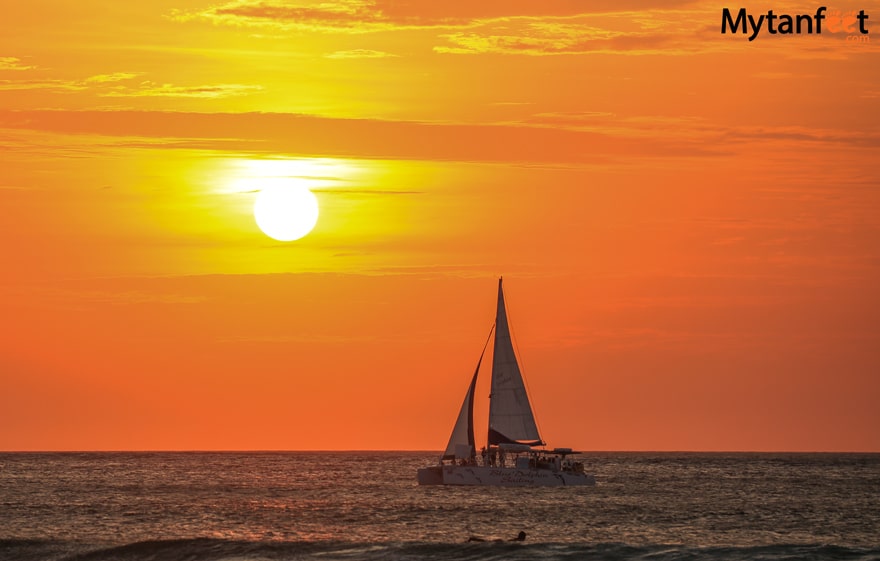 things to do in tamarindo with kids sunset sailing. A catamaran is sailing on the water during the sunset in Costa Rica 